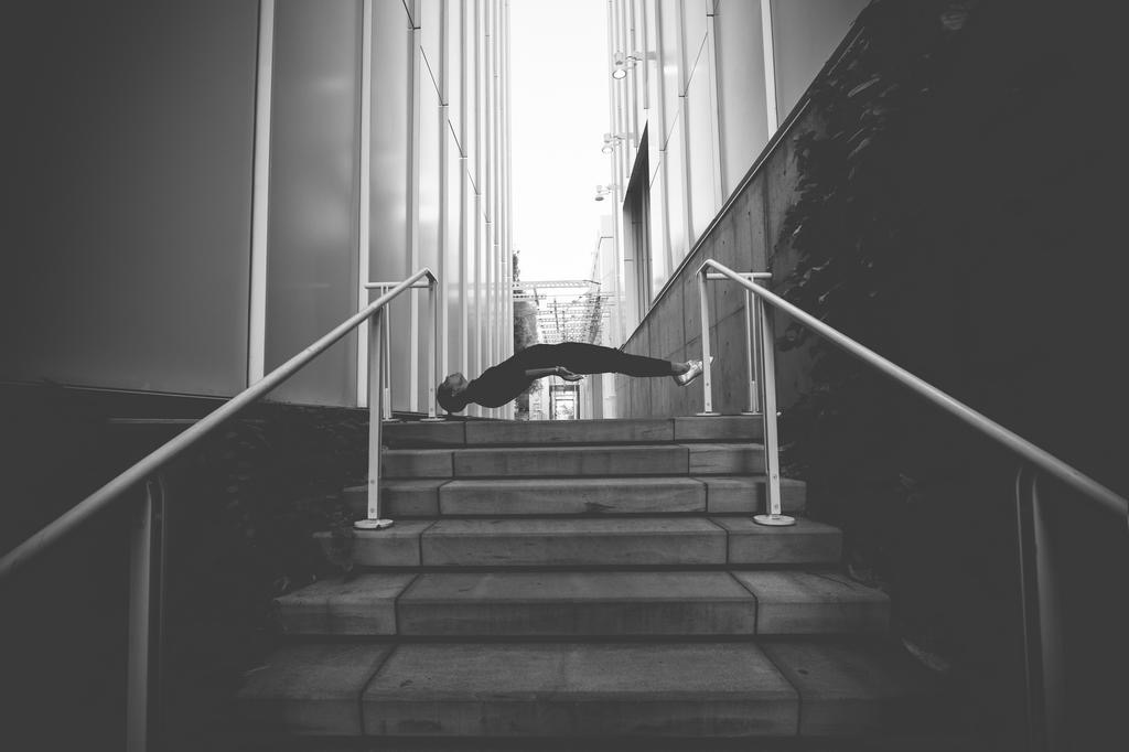 Figure floating horizontally above a modern staircase