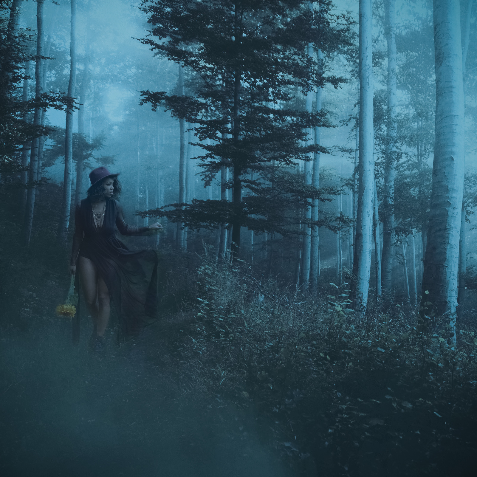 Figure in a burgundy hat and flowing dress in a misty blue forest