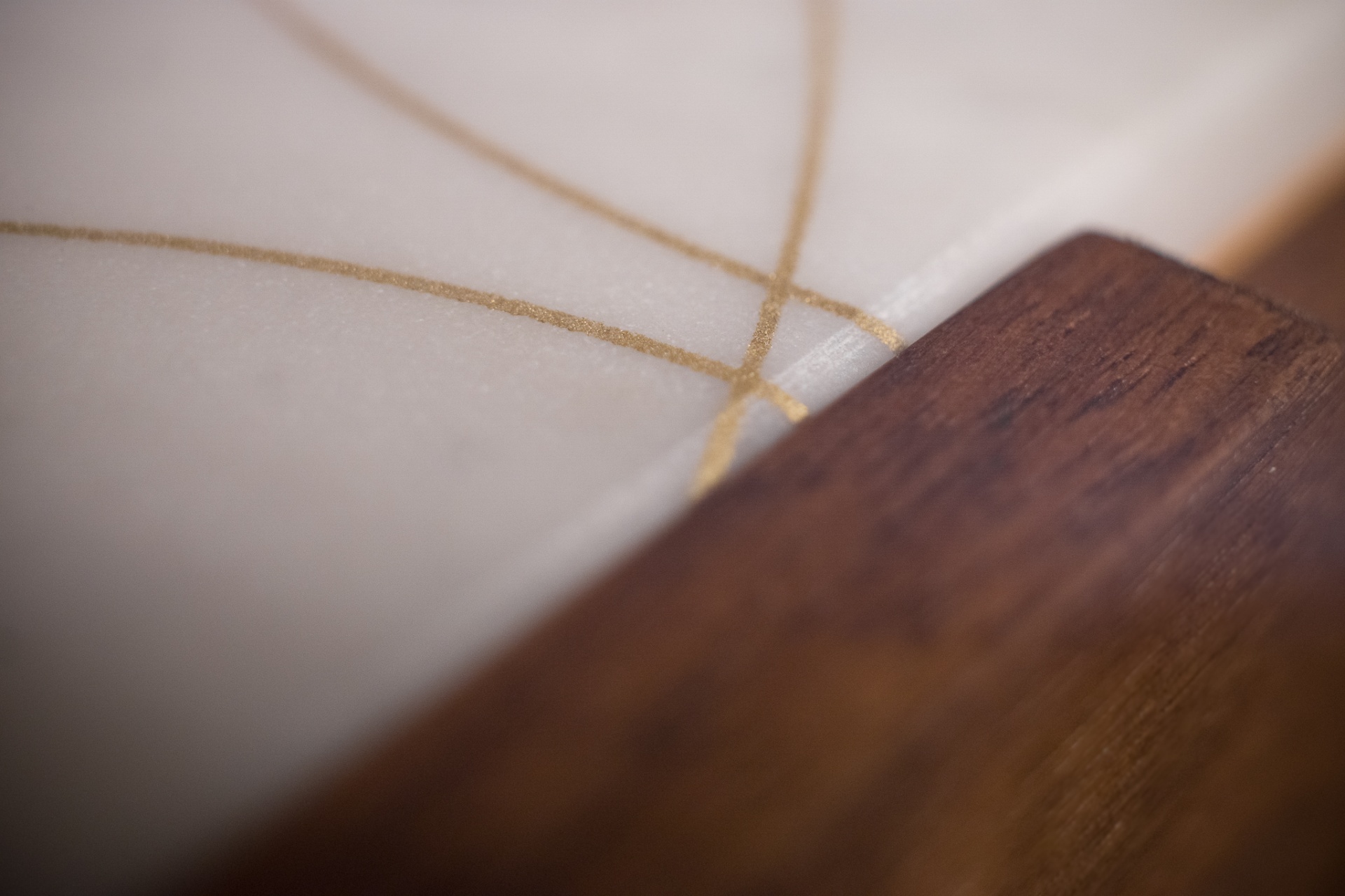 Close-up of the gold inlay lines meeting the walnut edge