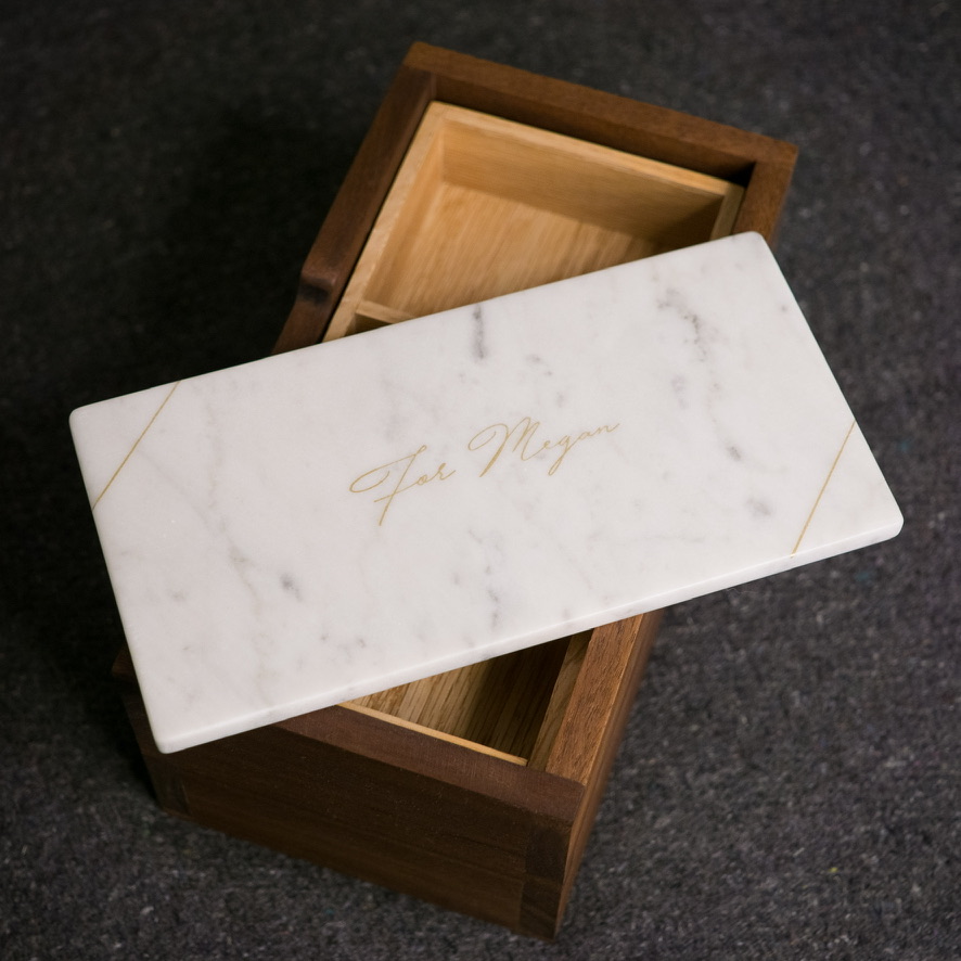 Marble lid engraved 'For Megan' resting on the open box